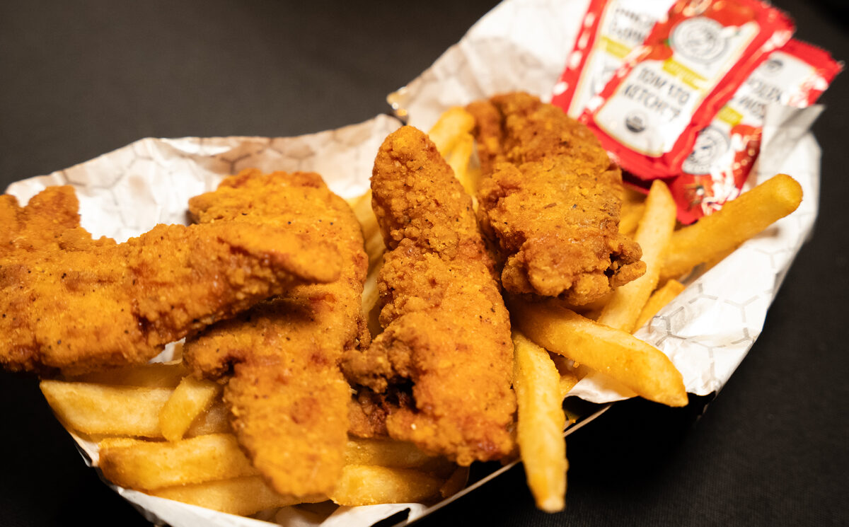 A basket of crispy fried chicken tenders with fries