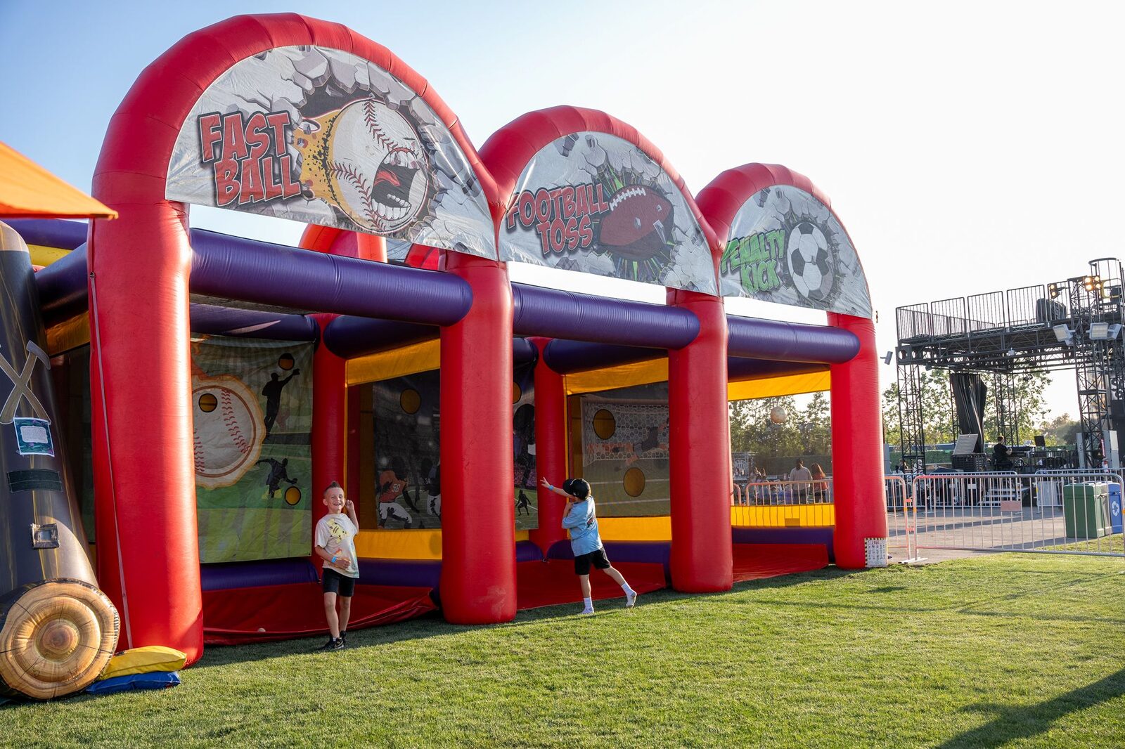 The Triple Threat inflatable's Fast Ball, Football Toss, and Penalty Kick lanes in action at the 2025 festival